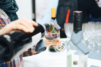 Midsection of man pouring wine in glass