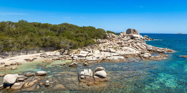 Scenic view of rocks in sea against blue sky