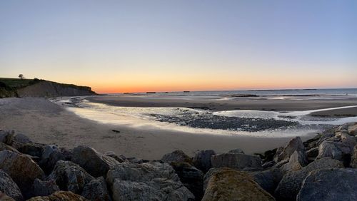 Scenic view of beach against sky during sunset