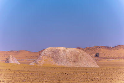 Scenic view of desert against clear blue sky