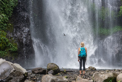 Rear view of boy looking at waterfall