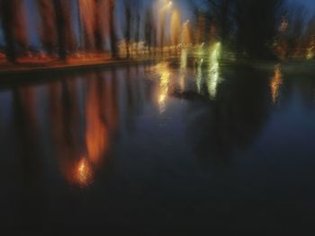 Reflection of trees in lake during sunset