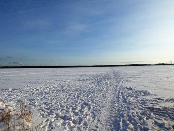 Scenic view of snow covered land against blue sky