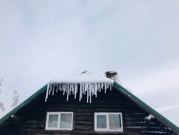 Icicles on the rooftop of a wooden house