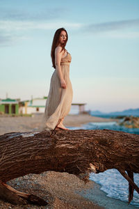 Young woman looking at sea shore against sky