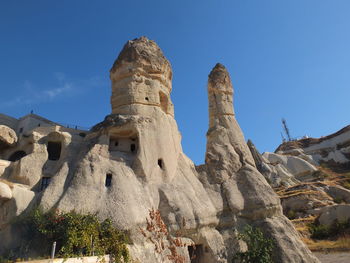 Low angle view of rock formation against blue sky