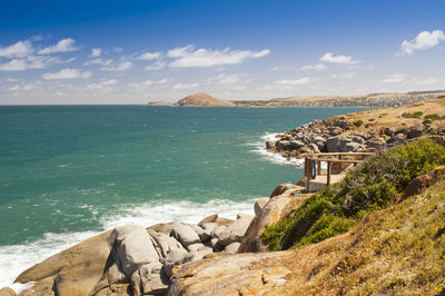 Young female tourist along the edge of granite island, south australia, near victor harbour.