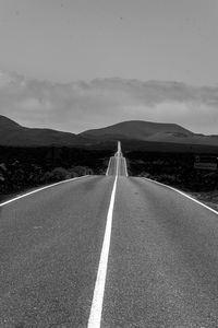 Empty road against mountain range