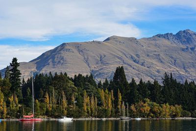 Scenic view of lake by mountains against sky