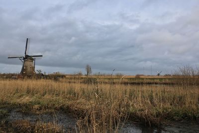 Traditional windmill on field against sky