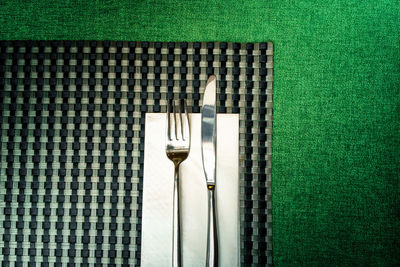 Close-up of fork with knife on place mat