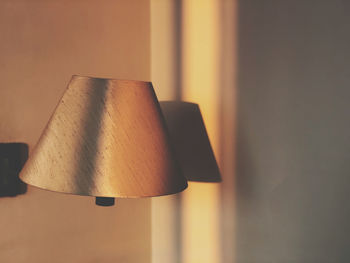 Close-up of lamp hanging against wall at home