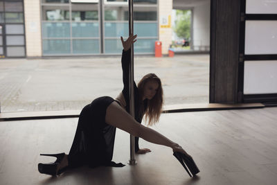 Rear view of young woman exercising in gym