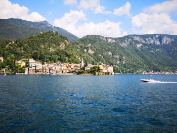 Scenic view of sea by townscape against sky