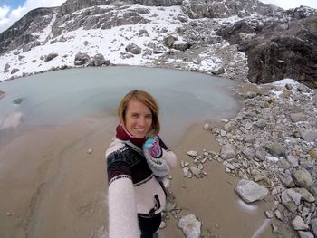 Portrait of smiling young woman standing on rock