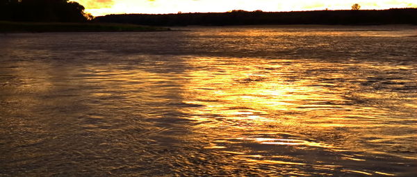 Scenic view of lake against orange sky