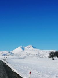 Scenic view of snowcapped mountains against clear blue sky