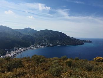 Scenic view of sea and mountains against sky