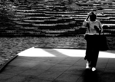 Rear view of woman standing against wall