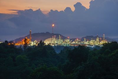 View of heavy industry factories during dawn surroundings by forest.