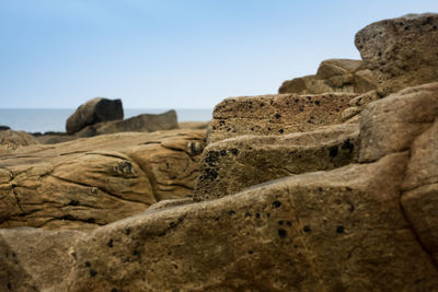 Rock formations on beach against clear sky