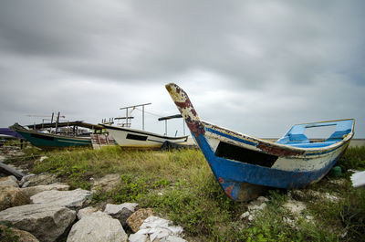 Ship moored at shore against sky