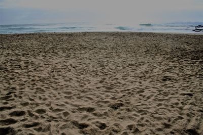 Close-up of sand on beach against sky