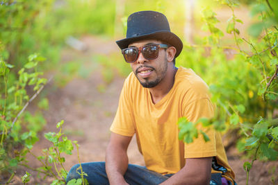 Young man wearing sunglasses sitting outdoors