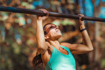 Female athlete exercising on gymnastics bar in park