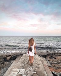 Rear view of woman standing on beach