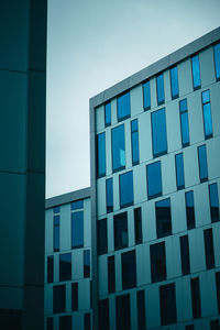 Low angle view of modern building against blue sky