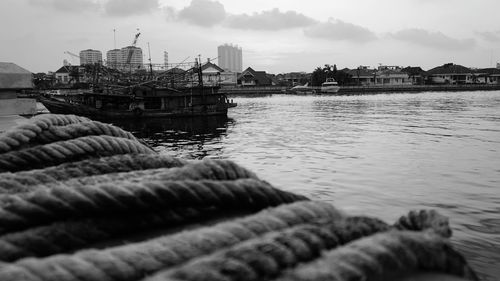 Scenic view of river by buildings against sky