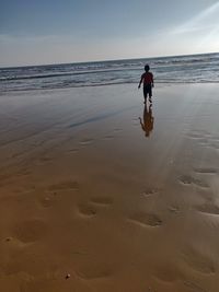 Full length of man on beach against sky