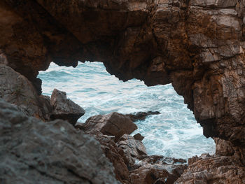 Scenic view of sea seen through cave
