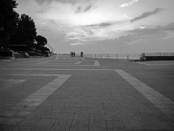 People by sea against sky in city