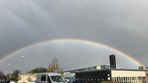 Rainbow over city against sky