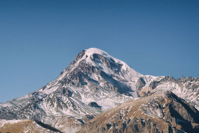 Scenic view of snowcapped mountains against clear blue sky