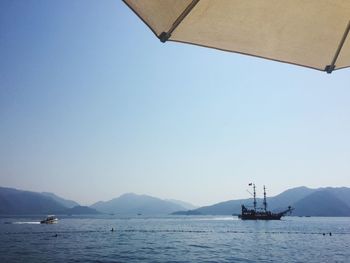 Sailboat sailing in sea against clear sky