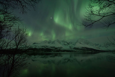 Scenic view of aurora borealis over lyngen alps and lake