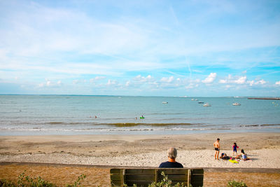 People on beach against sky