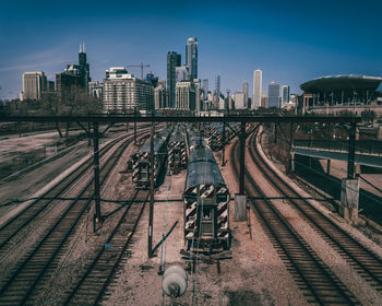 Railroad tracks amidst buildings in city against sky