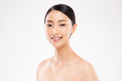 Portrait of a smiling young woman over white background