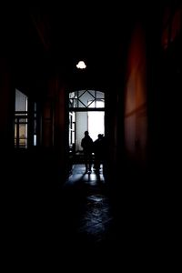 Silhouette people walking in corridor of building