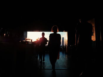 Rear view of silhouette people walking in city at night