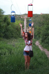 Woman walking under overhead cable cars on field