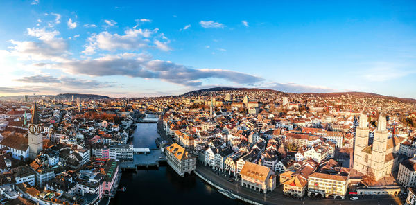 High angle view of illuminated city by river against sky