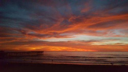 Scenic view of sea against dramatic sky during sunset