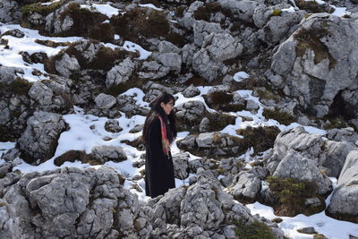 Rear view of woman standing on rock