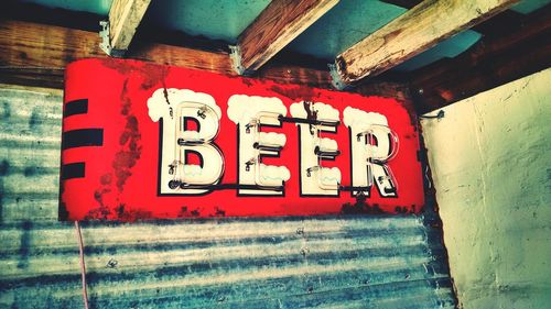 Close-up of beer sign on wall 