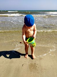 Full length of shirtless boy on beach